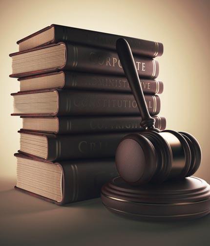 stack of legal book wth a gavel leaning against it